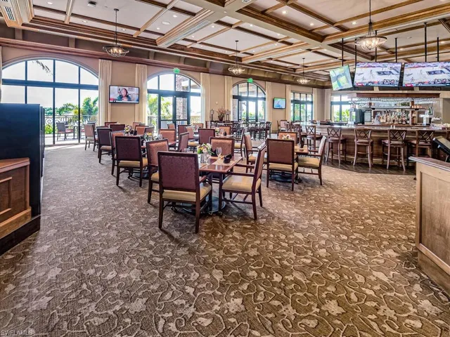 Dining room featuring beam ceiling, coffered ceiling, crown molding, and dark carpet