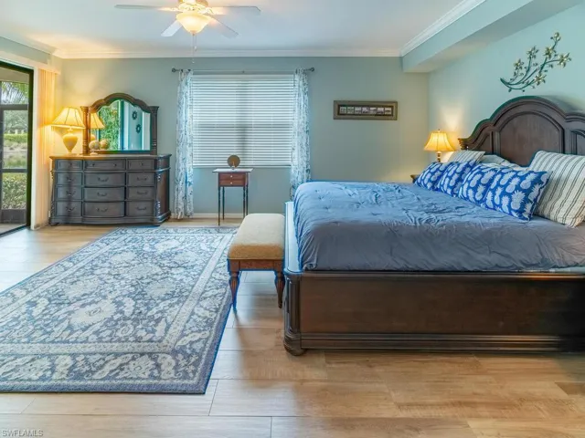 Bedroom featuring crown molding, light wood-type flooring, and ceiling fan