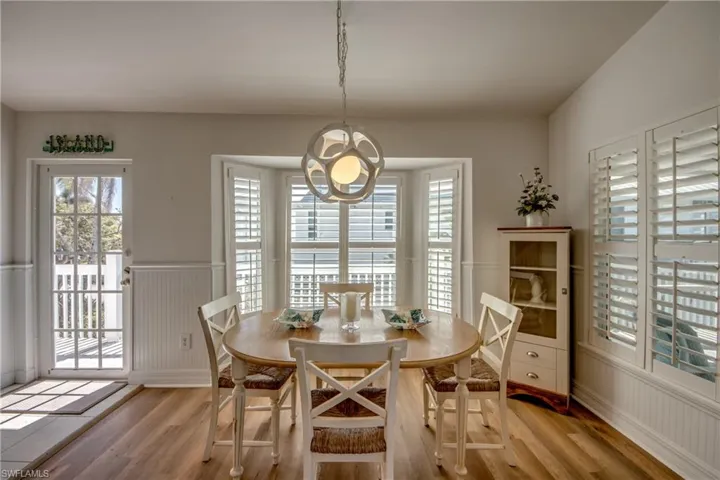 Dining space with light wood-type flooring and wainscoting