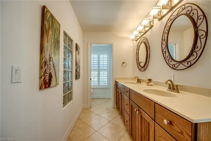 Full bath featuring double vanity and light tile patterned floors