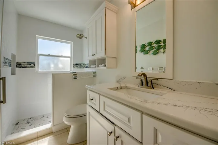 Bathroom with vanity, a shower stall, and light tile patterned flooring