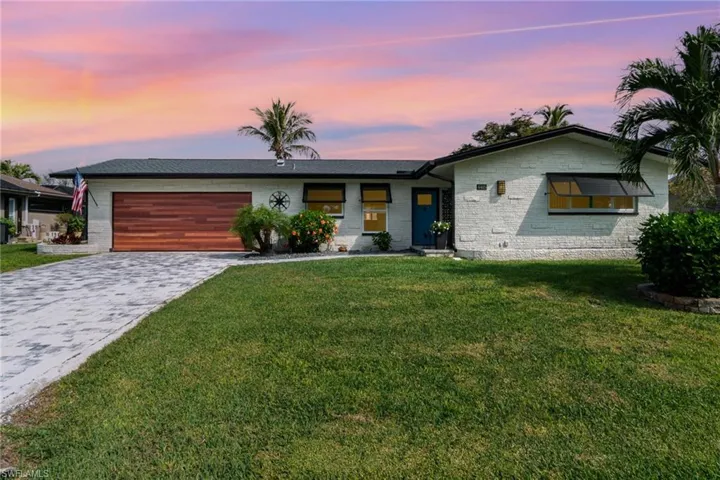 View of front of house featuring a garage and a lawn