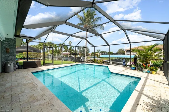 View of swimming pool with a patio and glass enclosure