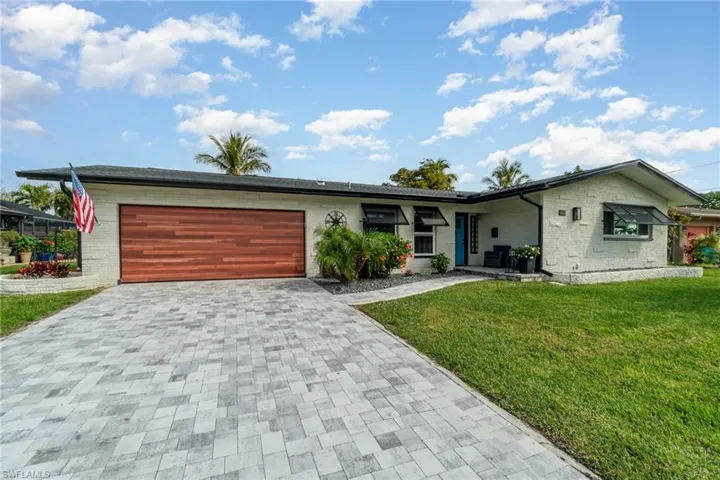 Single story home featuring a garage and a front lawn