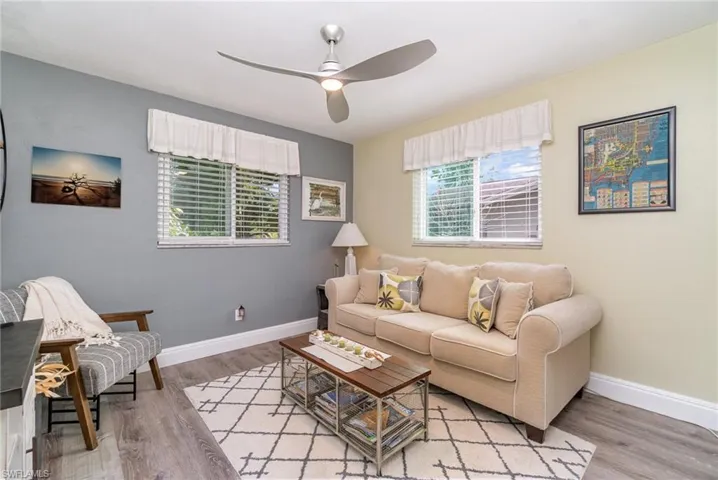 Living room with ceiling fan and light hardwood / wood-style flooring