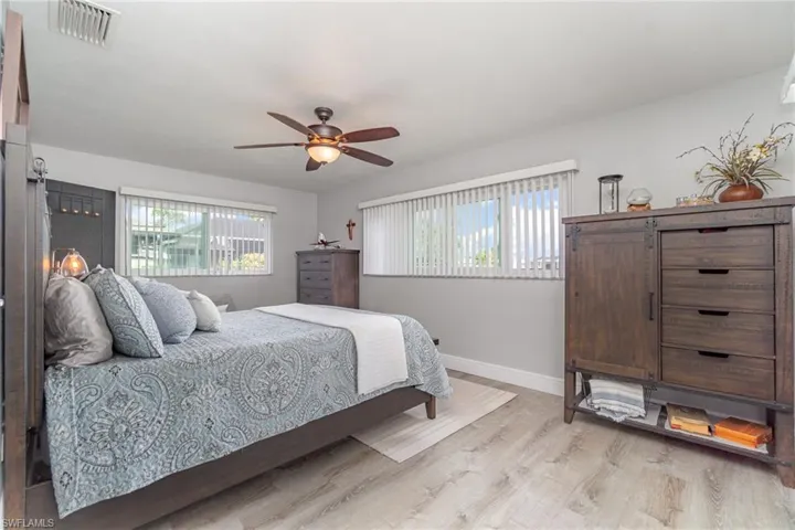 Bedroom featuring multiple windows, ceiling fan, and light wood-type flooring