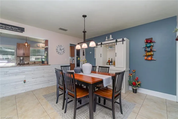 Dining space with a barn door and light tile patterned floors
