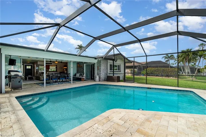 View of swimming pool featuring a patio, area for grilling, and glass enclosure