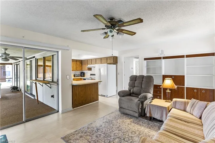 Living room featuring ceiling fan and a textured ceiling