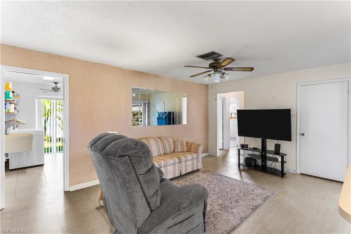Living room featuring ceiling fan and a textured ceiling
