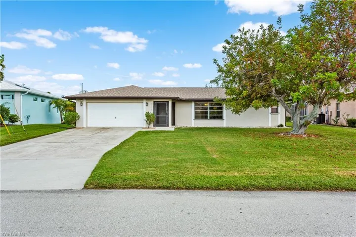 View of front of house featuring a garage and a front yard
