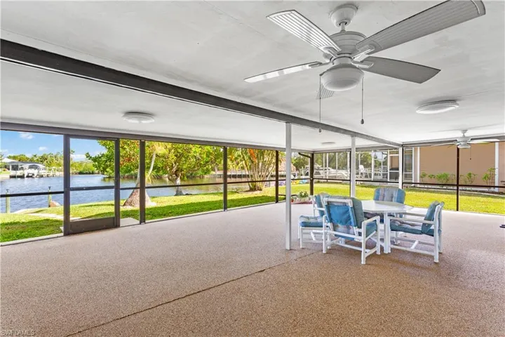 Unfurnished sunroom with a water view and ceiling fan
