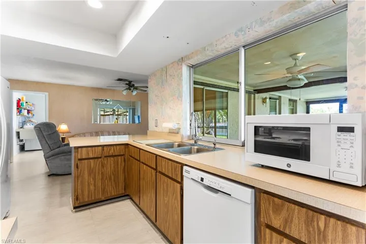 Kitchen with white appliances, sink, and kitchen peninsula