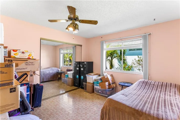 Bedroom featuring a textured ceiling, multiple windows, ceiling fan, and a closet