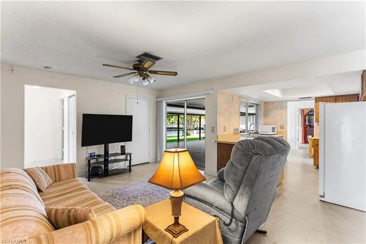 Living room featuring sink, a textured ceiling, and ceiling fan