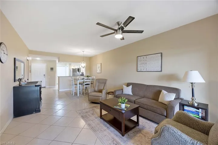 Living room with light tile patterned floors and ceiling fan
