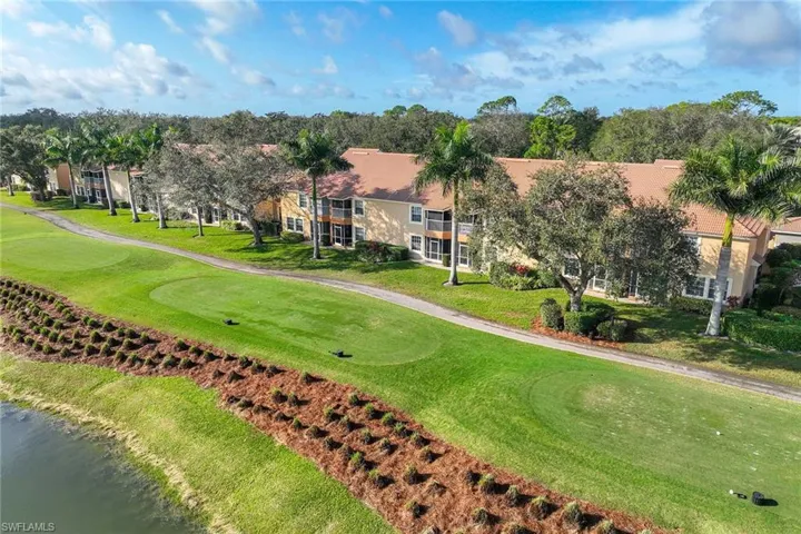 Surrounding community with golf course view, a lawn, and a putting green