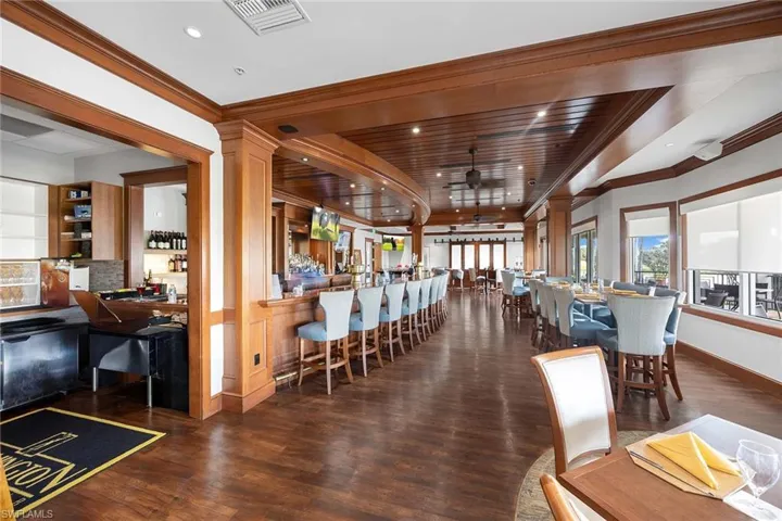 Bar featuring ceiling fan, ornamental molding, and wooden ceiling