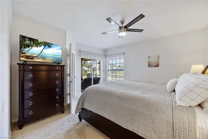 Bedroom with access to exterior, light carpet, and ceiling fan