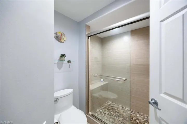 Bathroom featuring toilet and a shower stall
