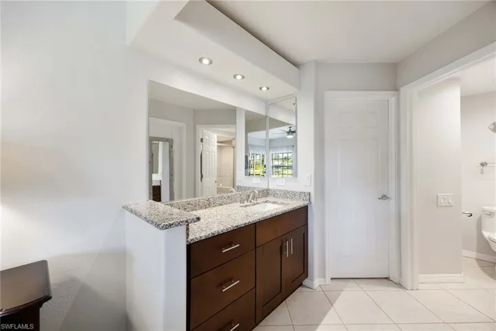 Bathroom with vanity, recessed lighting, light tile patterned floors, and a ceiling fan