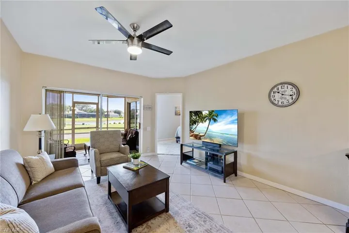 Living area with light tile patterned floors and a ceiling fan