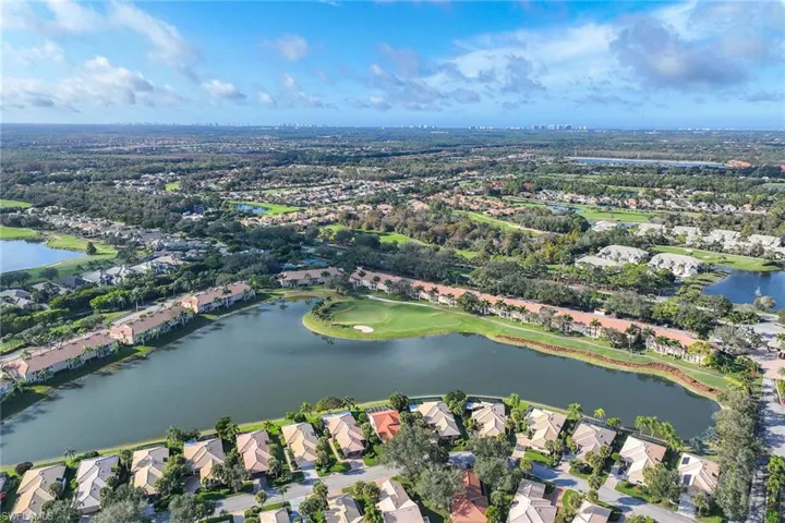 Aerial view of property's location featuring a nearby body of water, nearby suburban area, and a local golf course
