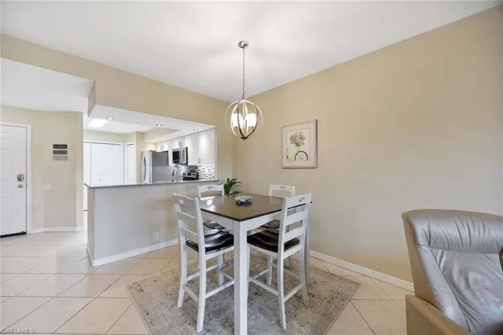 Dining space featuring light tile patterned floors and a chandelier
