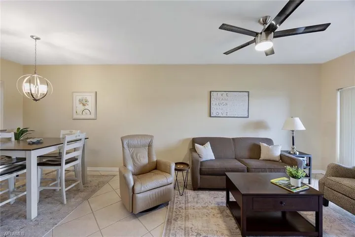 Living area with light tile patterned flooring and a ceiling fan