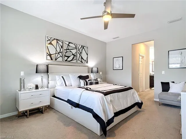 Bedroom with light colored carpet, visible vents, and baseboards
