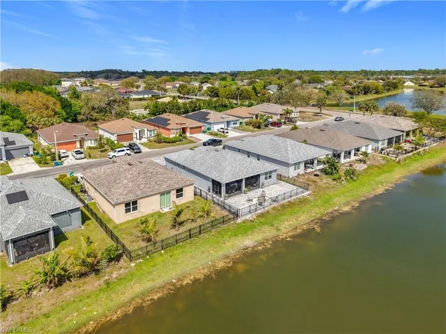 Birds eye view of property with a water view and a residential view