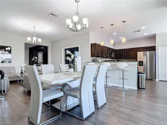 Dining room featuring visible vents, a chandelier, and wood finished floors