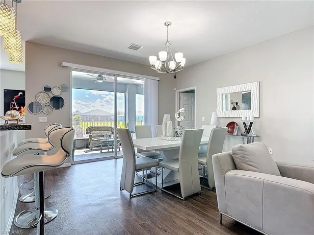Dining space featuring a chandelier, visible vents, and dark wood finished floors