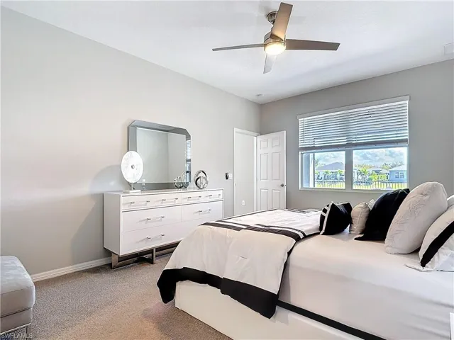 Bedroom with baseboards, a ceiling fan, and light colored carpet