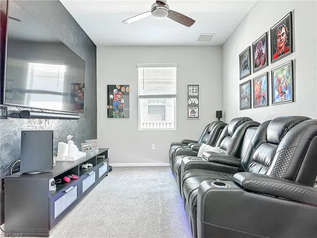 Living area with visible vents, light carpet, ceiling fan, a textured ceiling, and baseboards