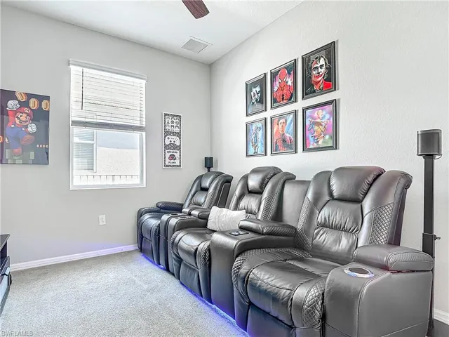 Home theater with a ceiling fan, baseboards, visible vents, and carpet flooring