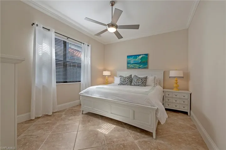 Guest Bedroom #3 with porcelain tiled bedroom with ceiling fan and crown molding