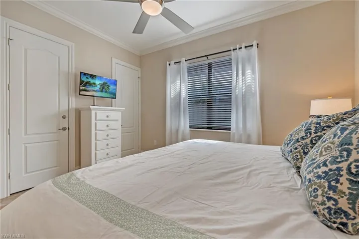 Guest Bedroom #3 with porcelain tiled bedroom with ceiling fan and crown molding