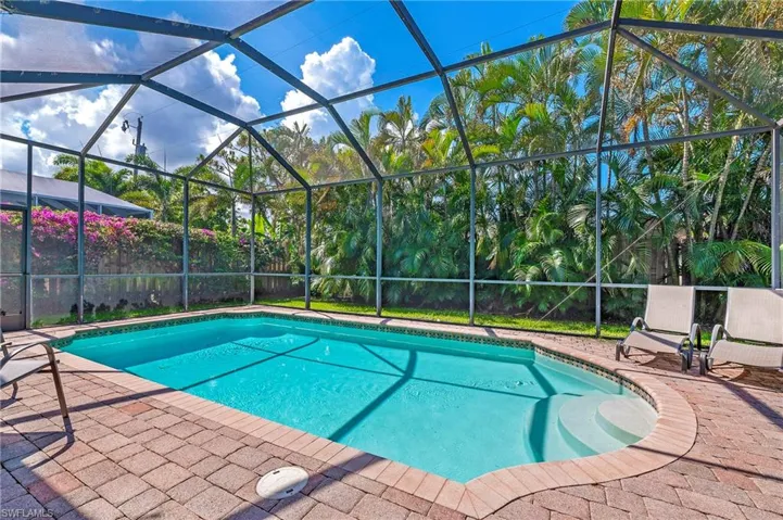 View of swimming pool featuring a screened enclosure