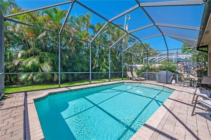 View of pool with a patio area and screen enclosure