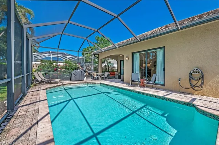View of swimming pool featuring grilling area, a lanai, and a patio area
