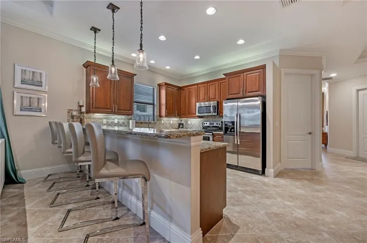 Kitchen with stainless steel appliances, granite counters, huge breakfast bar and wood cabinetry