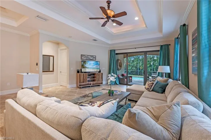 Great Room featuring ceiling fan, Crown molding, and a raised ceiling