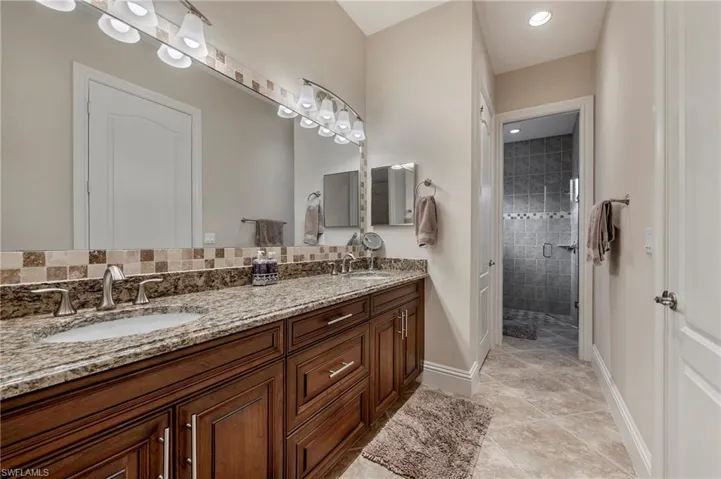 Primary Bathroom featuring vanity, an enclosed shower, and porcelain tiled flooring