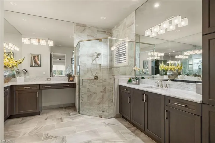 Floor to ceiling shower tile, vanity mirrors to the ceiling, updated vanity lighting, vanity area, dual sinks, and a bidet present here.