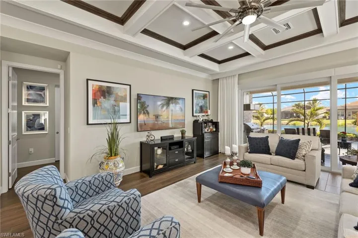 Easily seats 7 comfortably, this great room view shows entry to primary suite as well as the grand outdoor living space just steps away.