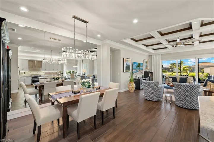 Custom wall mirror in dining room and classy chandelier dress up this dining room making you proud to invite friends and friends to dine!