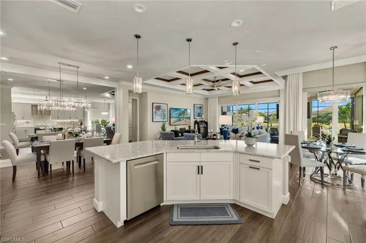 This view is a beauty and highlights all the classy lighting fixtures that seamlessly blend, and shows you have a lake view while doing the dishes!