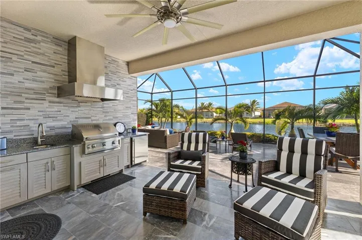 Luxurious outdoor kitchen w/ vent + sink, MARBLE lanai flooring, LAKE view, post closing upscale professional landscaping including lightscaping, huge extended lanai of over 1000sq ft + hurricane roll down shutters!!!