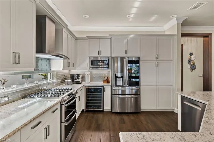 Check out the wine cooler, the glass tile backsplash, the gas stove, and the large window that allows in tons of natural light!